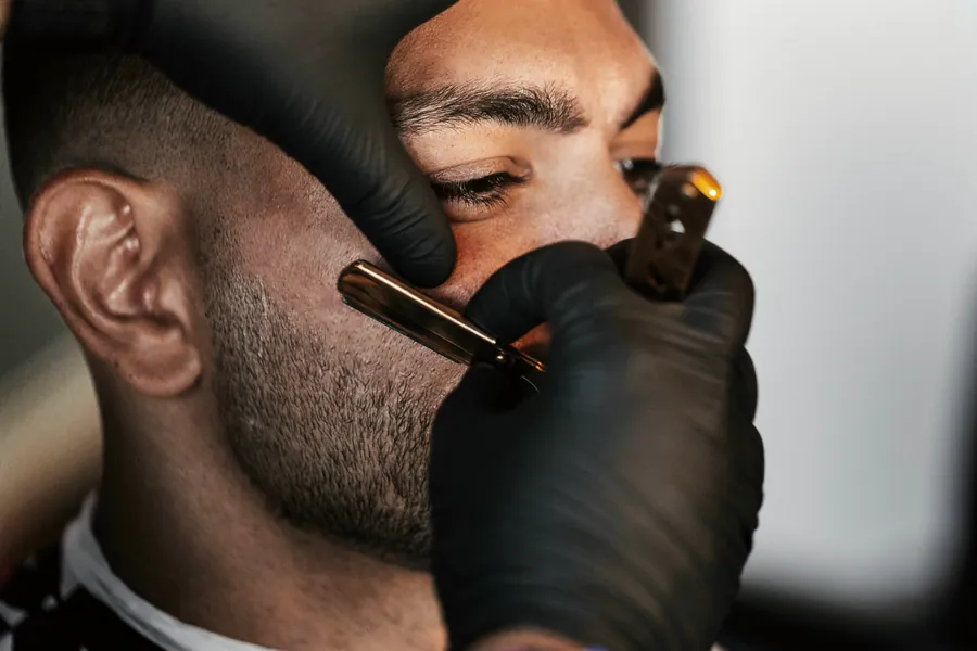 A straight razor edging a beard line along the cheek.