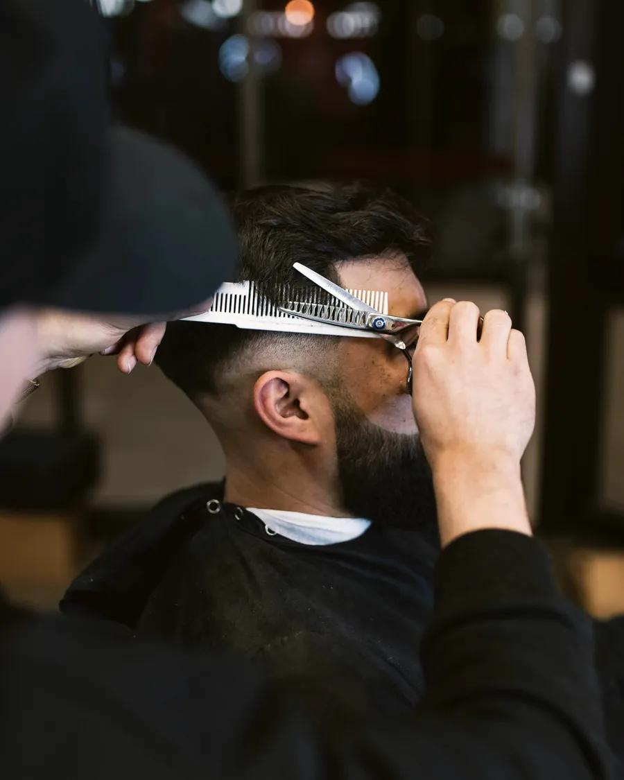 Scissor-over-comb detailing on the top of a bearded client's cut.